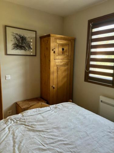 a bedroom with a bed and a wooden cabinet at Marmotton in Megève