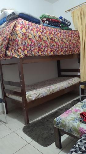 a bunk bed with a quilt on top of it at Hostel Meu Cantinho Caxambu Mg in Caxambu