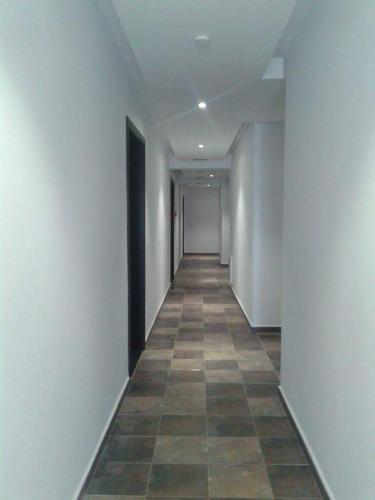 an empty hallway with white walls and a tile floor at Le lagon de Hammamet in Hammamet