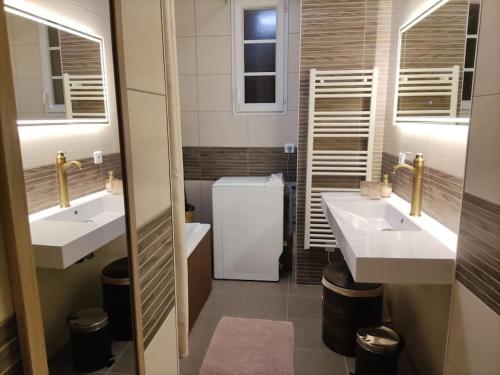 a bathroom with two sinks and a refrigerator at LE VEGAS Logis de luxe avec salle de jeux in Champagnole
