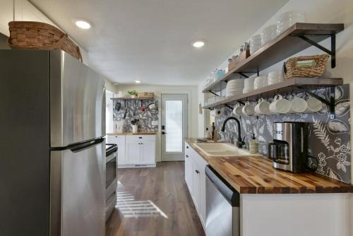 a kitchen with white cabinets and a wooden counter top at Laketown Cottages Blue Anchor in Rockaway Beach