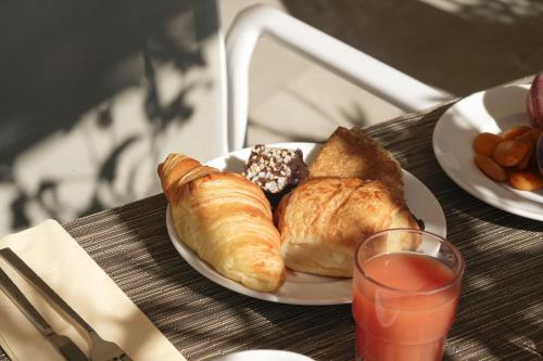 a plate of croissants and pastries on a table at Grand Prix Hôtel & Restaurant in Le Castellet