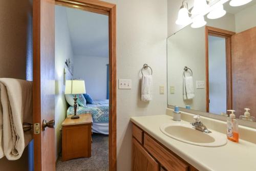 a bathroom with a sink and a mirror and a bed at Divine 9 Condo -Fishing Lake & Hiking Trails in Reeds Spring