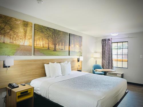 a hotel room with a bed and a painting on the wall at Days Inn by Wyndham WestEnd Alexandria,VA Washington DC Area in Alexandria