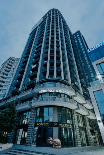 a tall building with a sign on the front of it at Luxury Inn Grand Residences in Tbilisi City