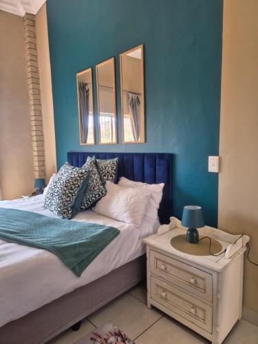 a bedroom with a bed with a blue wall at Jakkalswater guest farm in Nababeep