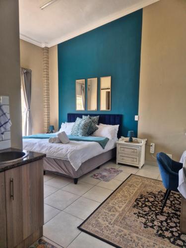 a bedroom with a bed and a blue wall at Jakkalswater guest farm in Nababeep