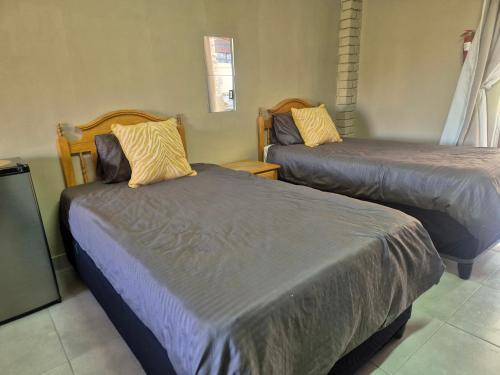 a room with two beds and two chairs at Jakkalswater guest farm in Nababeep