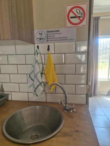 a sink in a kitchen with signs on the wall at Jakkalswater guest farm in Nababeep
