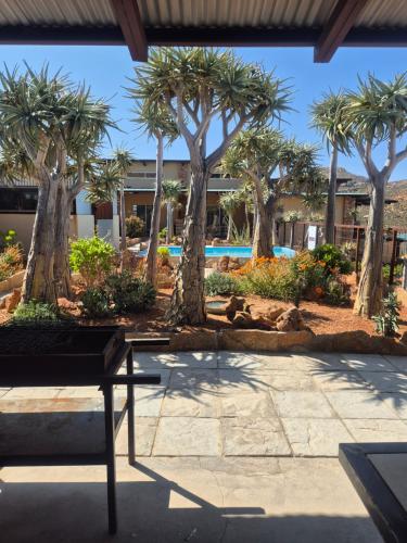 a resort with palm trees and a pool at Jakkalswater guest farm in Nababeep