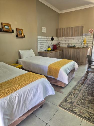 a hotel room with two beds and a kitchen at Jakkalswater guest farm in Nababeep