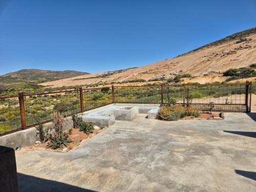 a patio with a fence and some plants at Jakkalswater guest farm in Nababeep
