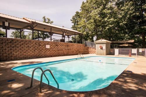 a swimming pool in a yard with a brick wall at Westcreek Ranch - No Stairs in Branson West