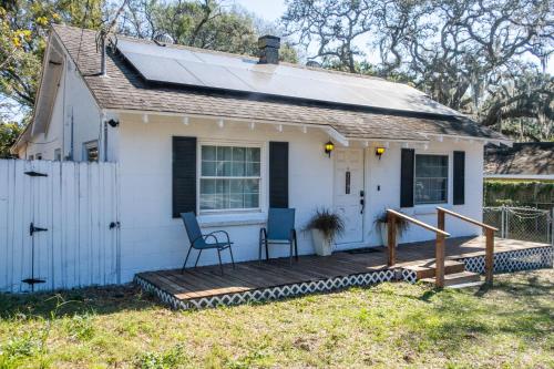 a small white house with two chairs on a porch at Cozy Home near Busch Gardens Adventure Island and USF in Tampa