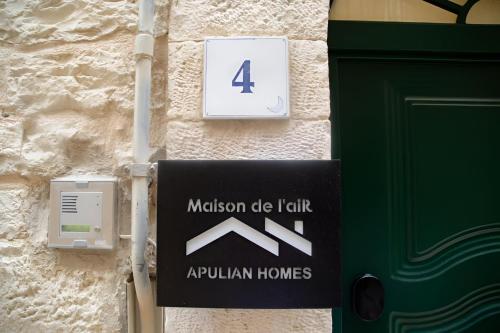 a sign on the side of a building with a green door at Maison de l'aiR - apt with Jacuzzi in Giovinazzo