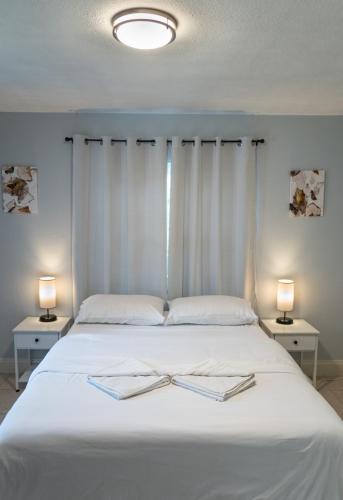 a bed with two books on it with two lamps at Cozy Home near Busch Gardens Adventure Island and USF in Tampa