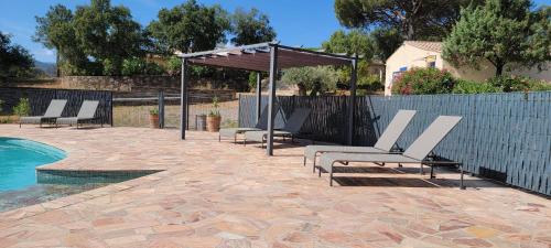 a group of chairs sitting next to a swimming pool at Le Mas du Rouquan in Vidauban