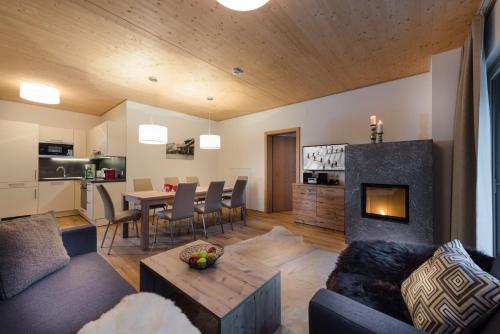 a living room with a couch and a fireplace at AlpenParks Hotel & Apartment Central Zell am See in Zell am See