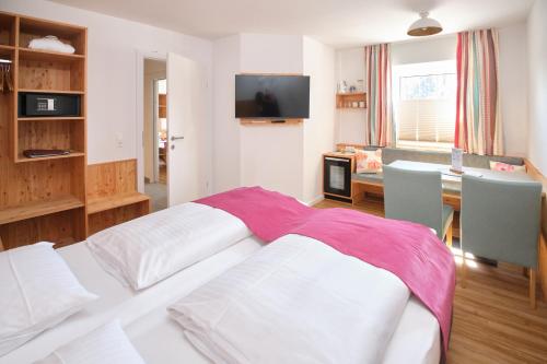 a living room with a bed and a dining room at Santner, Hotel in Eugendorf