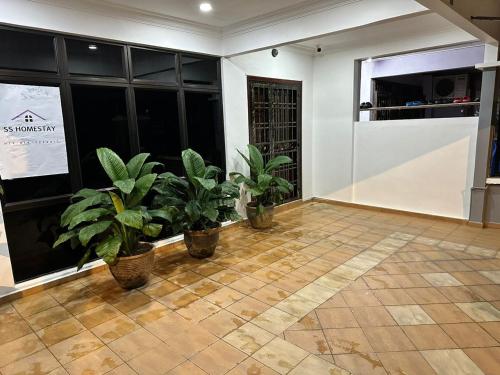 a room with potted plants on a tile floor at SS Homestay in Johor Bahru
