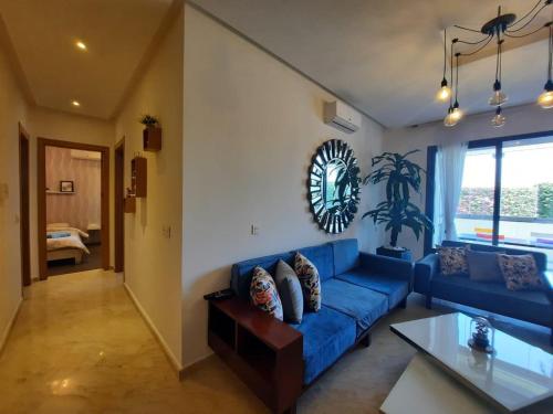 阿加迪尔Superbe appartement Résidence Hivernage Founty Agadir的客厅里有一张蓝色的沙发和一张桌子