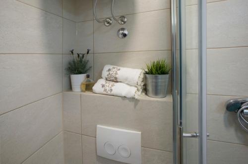 a shower stall with three towels and potted plants at Dionis UNESCO Luxury apartment in Split