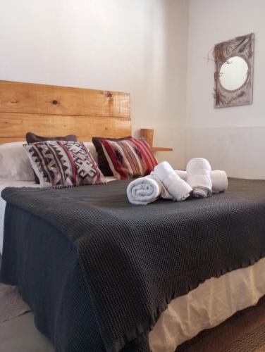 a bed with two rolled towels on top of it at Casa Inkill Huasi in Tilcara