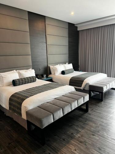 a hotel room with two beds in a room at Baruk Guadalajara Hotel de Autor in Guadalajara