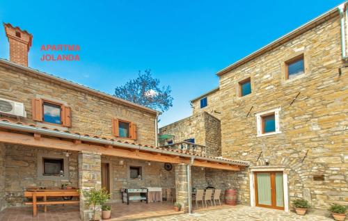 a large stone building with a patio in front of it at Apartma Jolanda in Šmarje