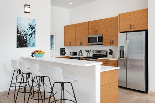 a kitchen with white counter tops and wooden cabinets at Byculla Villa - Canal front in Long Bay Hills