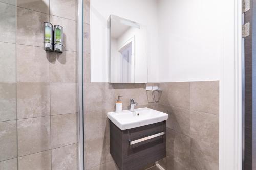 a bathroom with a sink and a shower at Stylish Retreats on Olympic Way in London