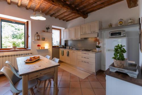 a kitchen with a wooden table and a dining room at Agriturismo Casale le Crete in Acquapendente