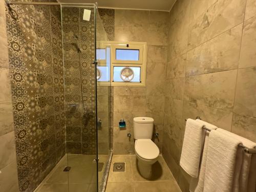 a bathroom with a toilet and a glass shower at Gabry Grand Egyptian Museum and Pyramids Hotel in Cairo