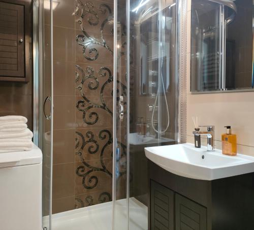 a bathroom with a shower with a sink and a toilet at 7th Floor Apartment Mokotów - Mordor, Airport, Parking in Warsaw