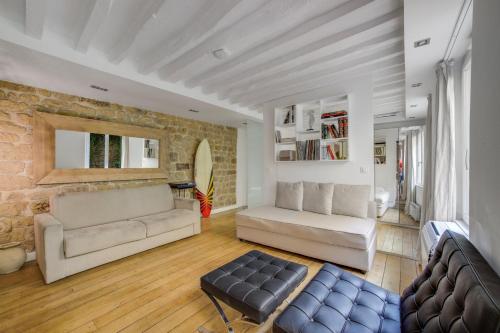 - un salon avec deux canapés et un mur en pierre dans l'établissement Hot Hot Hot Loft Faubourg Saint-Denis, à Paris