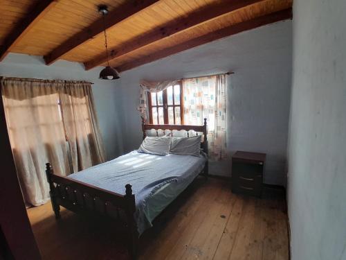 a bedroom with a bed in a room with a window at Departamento Draiggoch in Trevelin