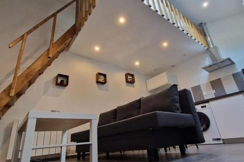 a living room with a black couch and a table at Résidence ROZ 2 in Antony