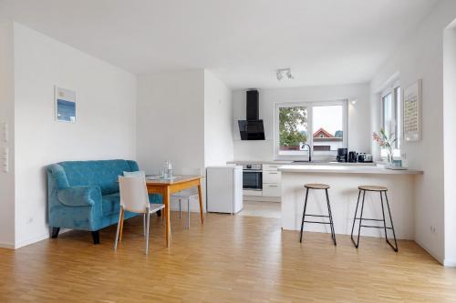 a kitchen with a blue couch and a table and chairs at Auszeit am Wiehengebirge in Bad Essen