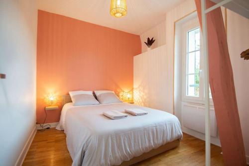 une chambre avec un lit blanc avec deux serviettes dessus dans l'établissement La Motte Bridard - 2 chambres - 1 canapé-lit - Parking - Jardin, à Appoigny