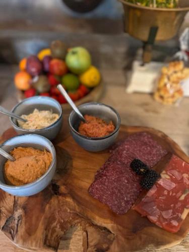 a table with bowls of food on a cutting board at Imagine B&B in Wortegem