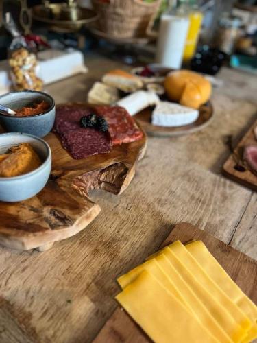 a wooden table topped with different types of food at Imagine B&B in Wortegem