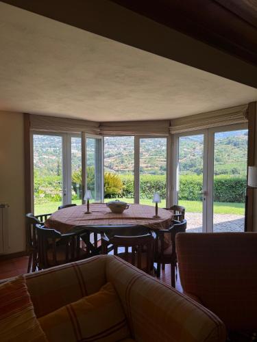 a dining room with a table and chairs and windows at Quinta da Ponte in Resende