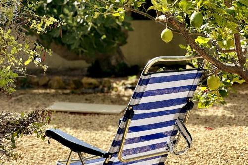 a blue and white chair sitting under a tree at Beachfront, First line, 2-Bdr,2-Bath, Swiming Pool in Albir