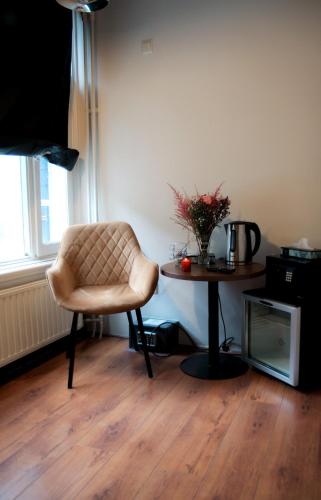 a living room with a chair and a table at Hotel 55 - City Centre in Amsterdam