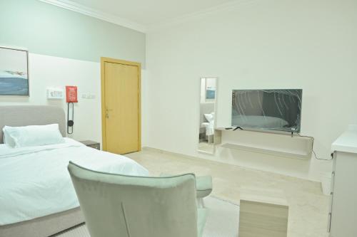 a hospital room with a bed and a tv at Modern & New furnished Apartments - 10 Mins Drive to Beach in Al Bādīyah