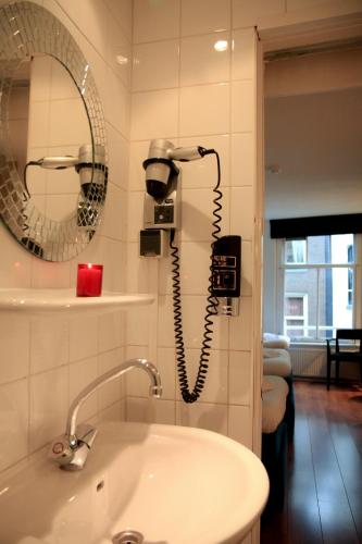 a bathroom with a phone on the wall next to a sink at Hotel 55 - City Centre in Amsterdam
