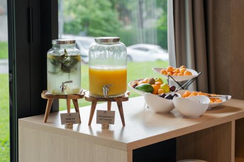a table with two jars of orange juice and bowls of fruit at Hotel Soča in Bovec