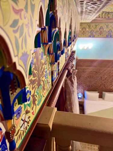 a room with a wall filled with colorful vases at Riad Al Fassia Palace in Fès
