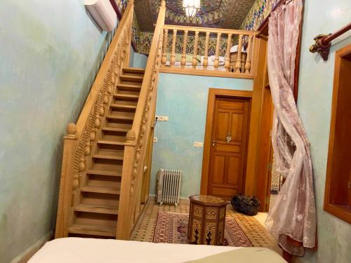 a wooden staircase in a room with a bedroom at Riad Al Fassia Palace in Fès