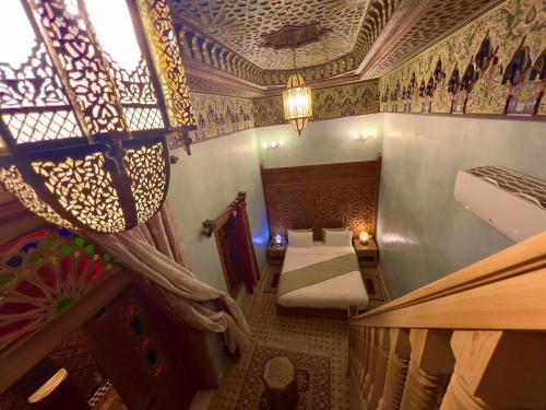 a room with two beds and a ceiling at Riad Al Fassia Palace in Fès